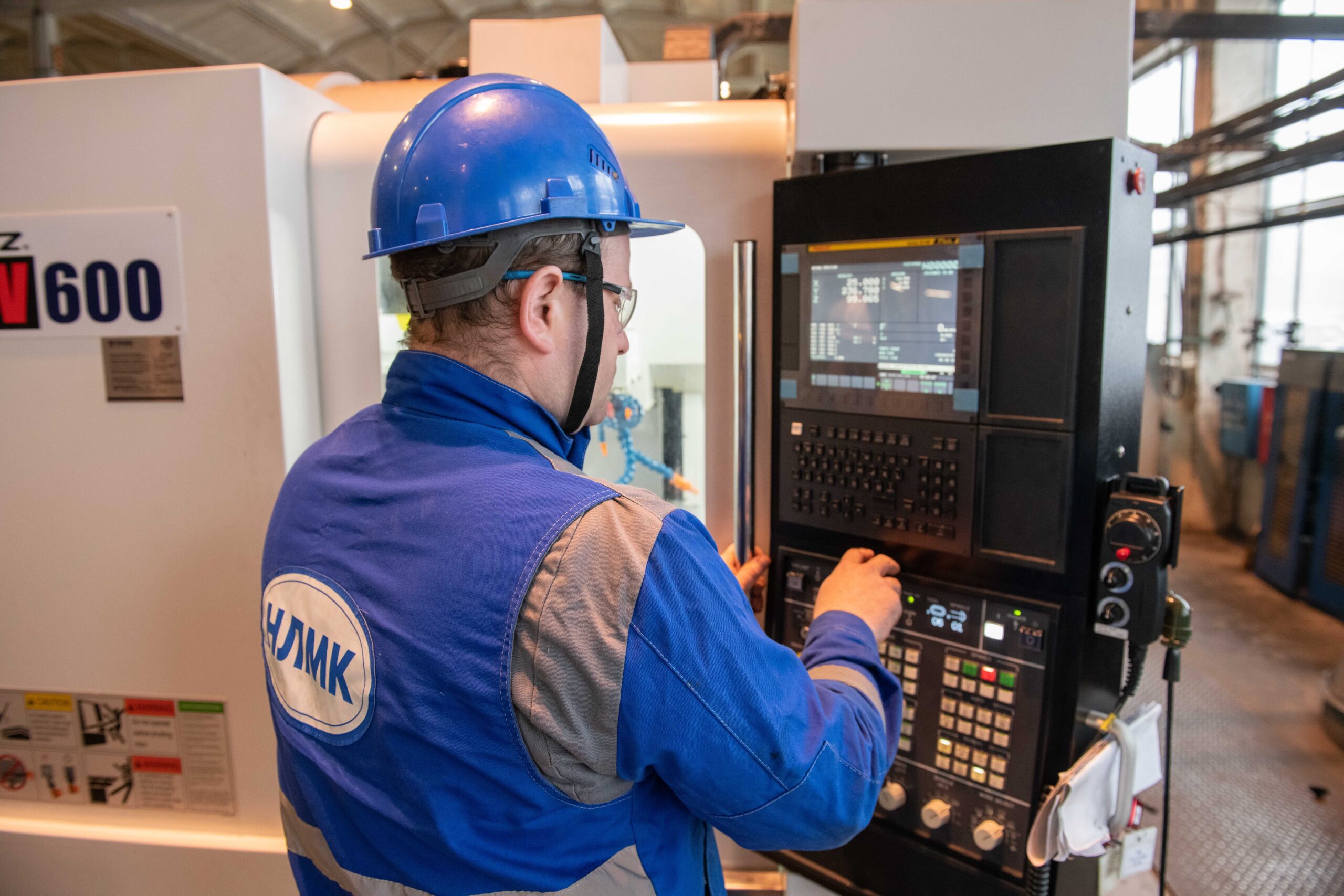 CNC operater upravlja industrijskom mašinom u fabrici